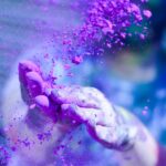 pexels-photo-1927595-1927595 Close-up of hands throwing vibrant purple powder outdoors, capturing motion and color.